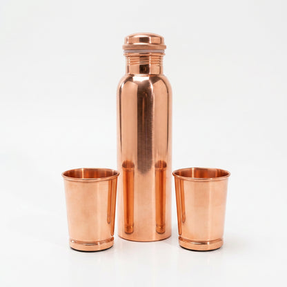 Kupfer-Trinkset Ayurveda glatt auf weißem Hintergrund, Flasche und zwei Becher