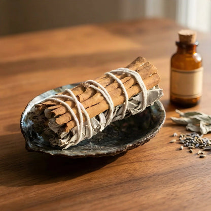 Salbeibündel mit Zimt in einer Abalone-Schale auf einem Holztisch