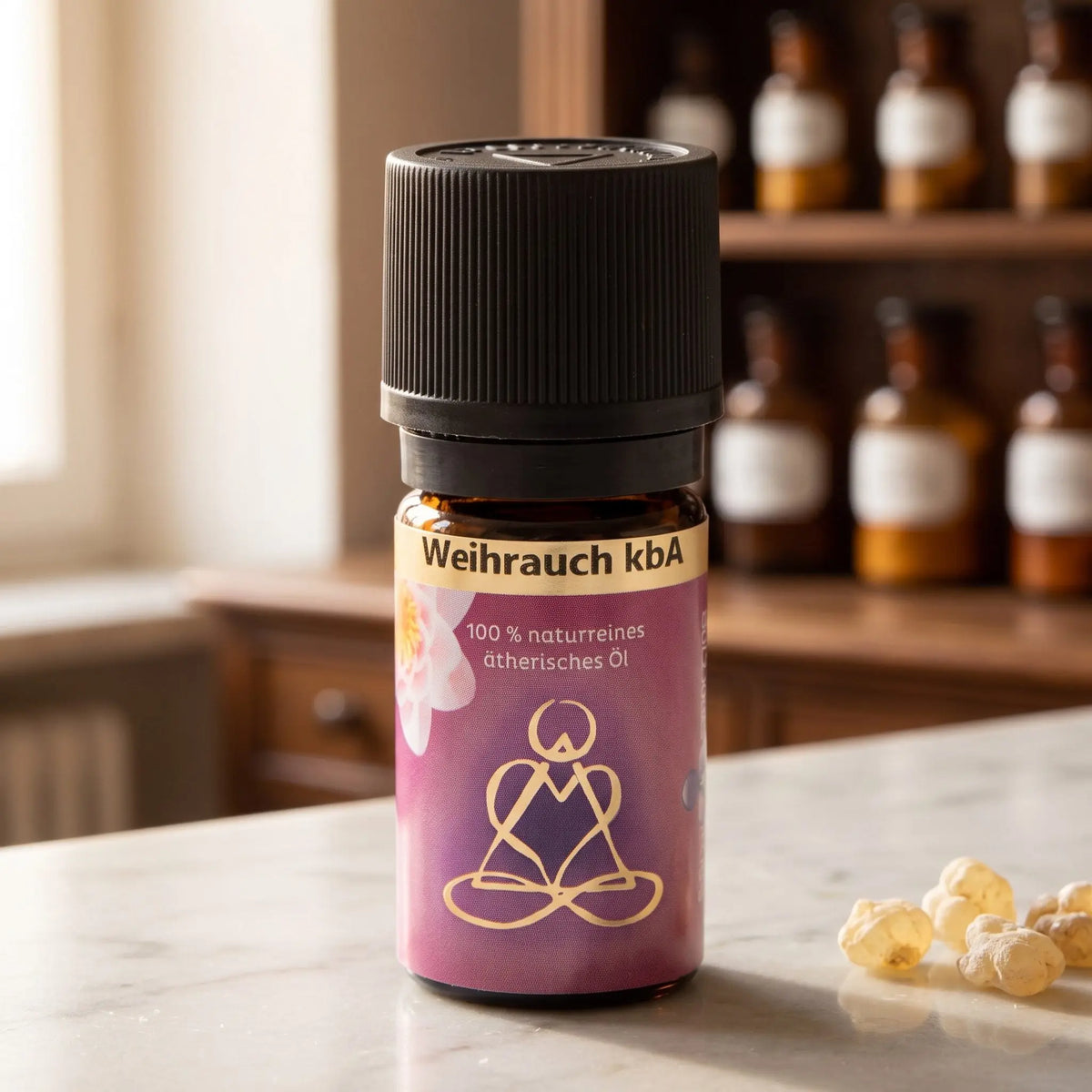 Ätherisches Öl Weihrauch: Fläschchen aus Braunglas auf Marmortheke vor Apothekerschrank, daneben Weihrauchharz – Spirit of Gaia