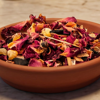 Verbindung zur Urkraft II, Räuchermischung der Reihe Einfach Räuchern von Berk, 50 ml im Korkglas: Nahaufnahme der Terracottaschale mit Rosenblüten und Harzstücken vor der warmen, unscharfen Abendapotheke – Spirit of Gaia
