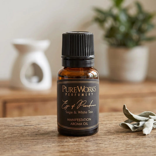 Aromaöl Eye of Providence (Salbei & weißer Tee): Fläschchen auf einem Holz-Sideboard im Wohnzimmer, im Hintergrund eine weiße Duftlampe, daneben getrocknete Salbeiblätter
