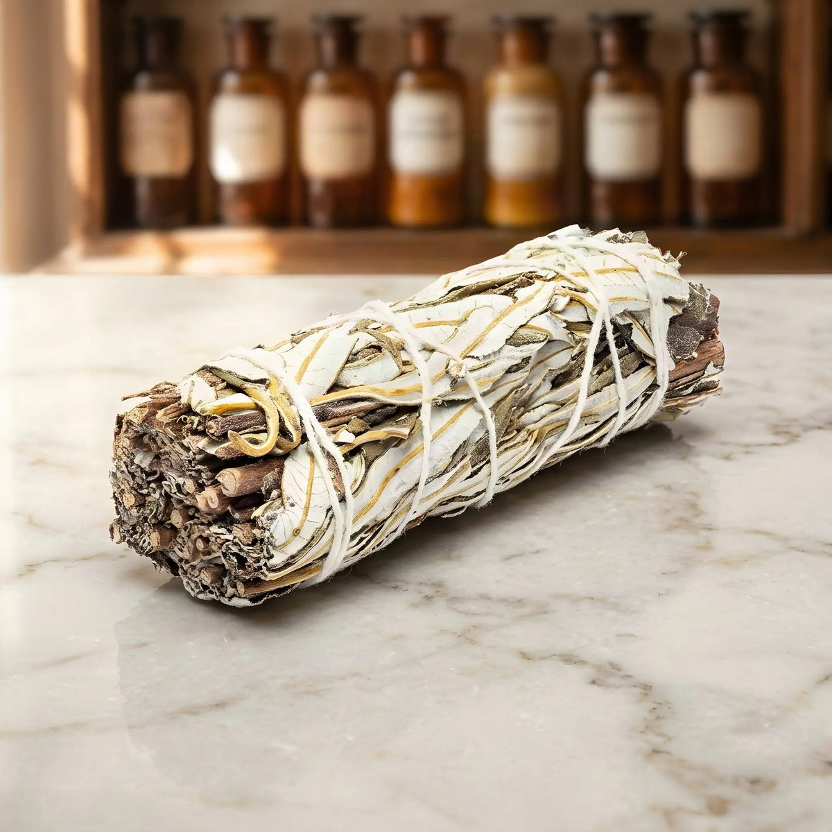 Sortenreines Yerba-Santa-Bündel auf Marmorablage vor einem Apothekerschrank – Spirit of Gaia