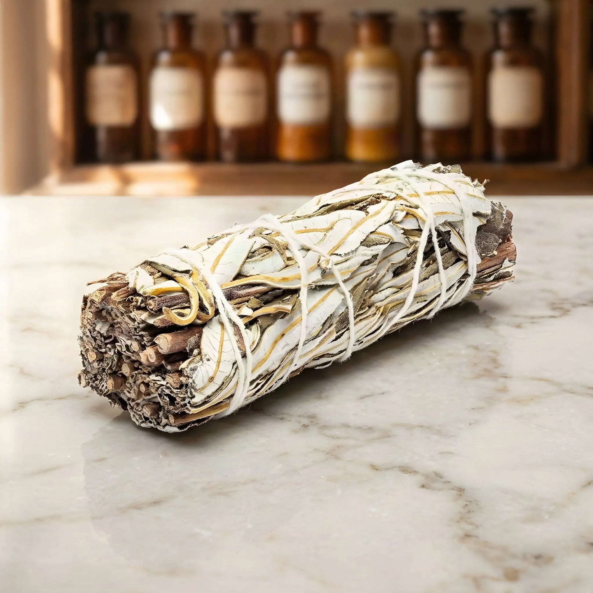 Sortenreines Yerba-Santa-Bündel auf Marmorablage vor einem Apothekerschrank – Spirit of Gaia