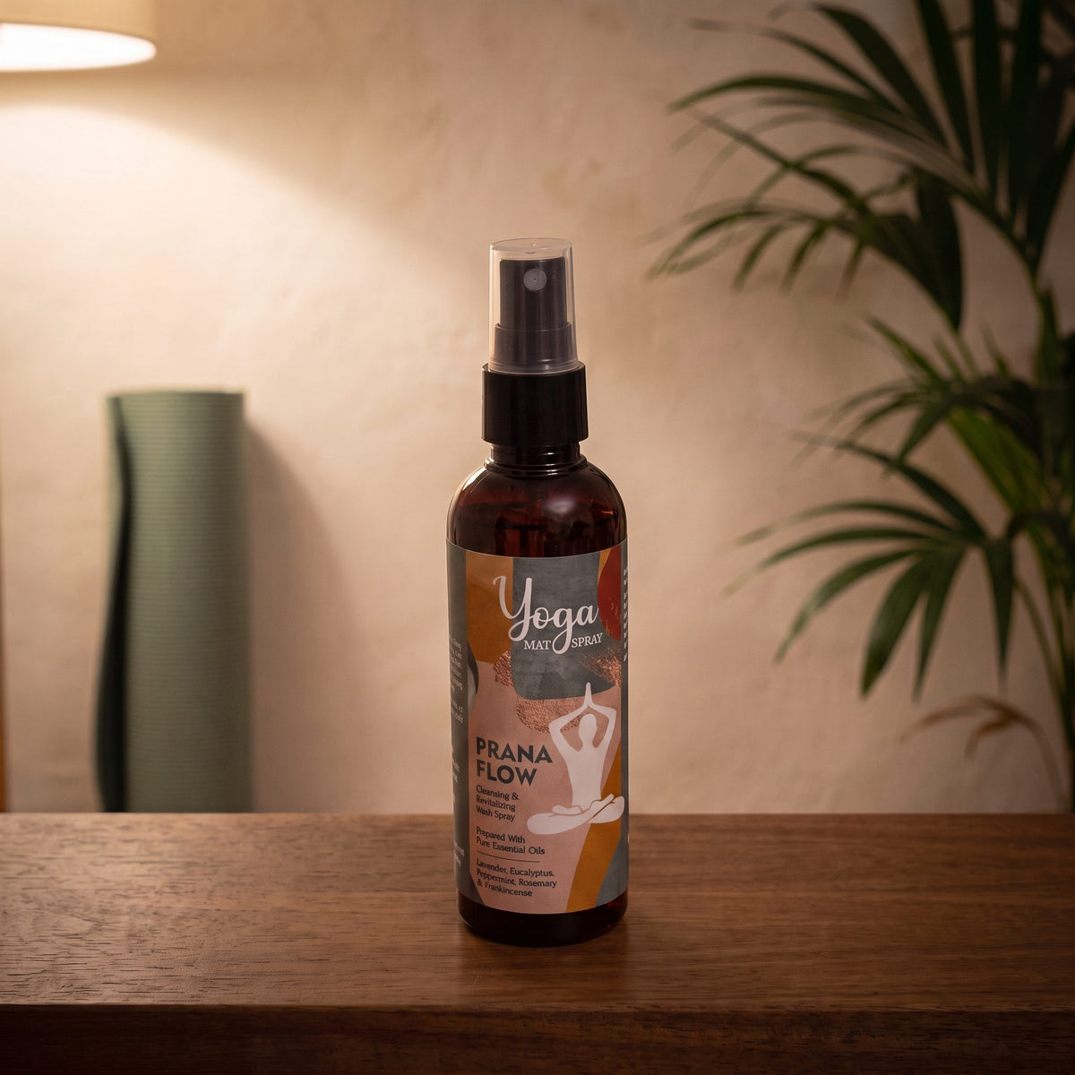 Yogamatten-Spray Prana Flow von Song of India, 100 ml, auf einer dunklen Holzbank in einem Meditationsraum, dahinter eine aufgerollte Yogamatte