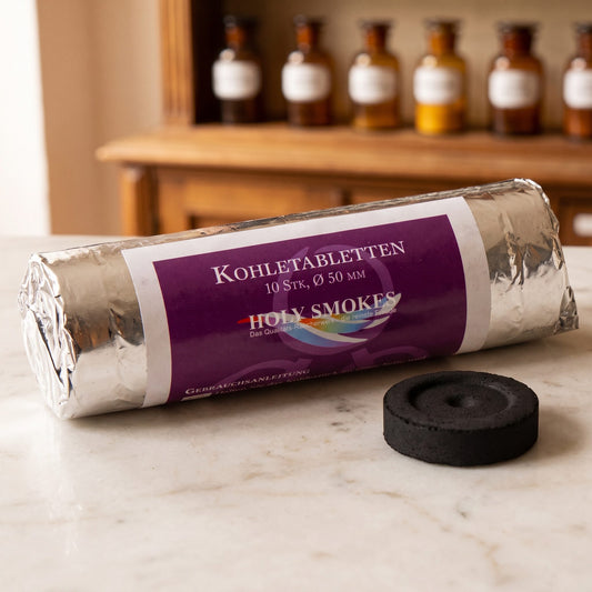 Kohletabletten 5 cm auf einer Marmortheke vor einem Apothekerschrank – Spirit of Gaia