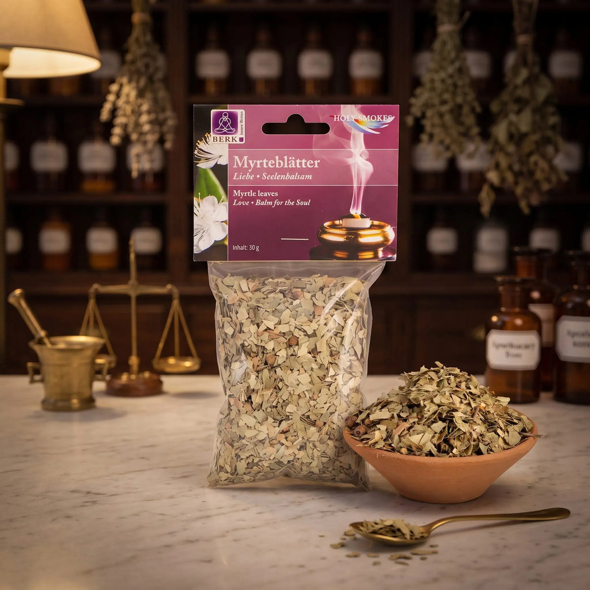 Myrteblätter, sortenreines Räucherwerk von Berk, 30 g: Packung auf der Marmortheke einer alten Apotheke am Abend, daneben eine Terracottaschale mit getrockneten Myrteblättern und ein Messinglöffel – Spirit of Gaia