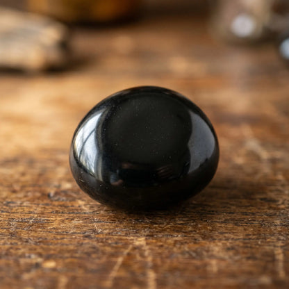 Obsidian Trommelstein – Detail-Makro der glänzenden schwarzen Vulkanglas-Oberfläche