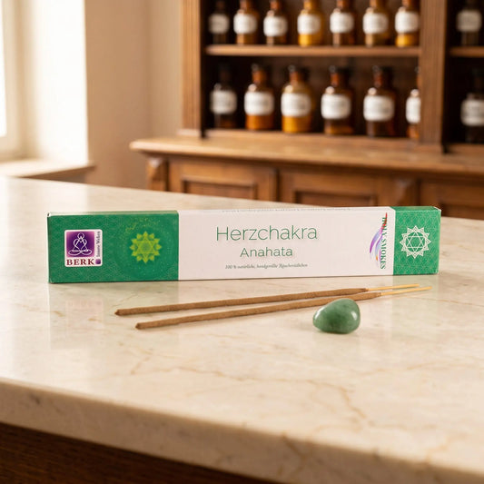 Herzchakra Räucherstäbchen Holy Smokes: Packung auf einer Marmortheke vor einem Apothekerschrank, daneben zwei lose Räucherstäbchen und ein Trommelstein – Spirit of Gaia
