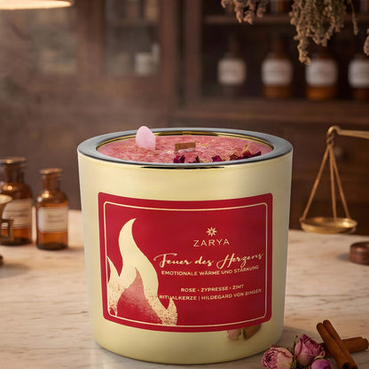 Zarya Kerze Feuer des Herzens im Glas mit Etikett auf der Marmortheke einer Apotheke am Abend, daneben Rosenknospen und Zimtstangen